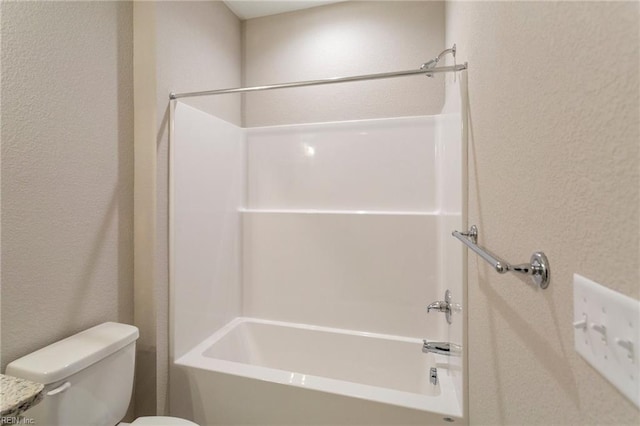 bathroom featuring shower / tub combination and toilet