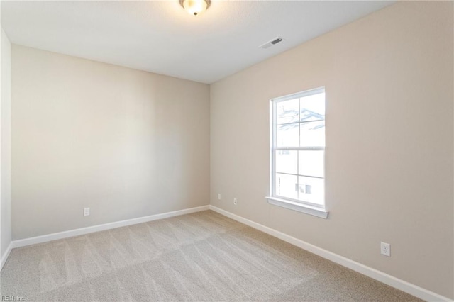 spare room with a wealth of natural light and light colored carpet