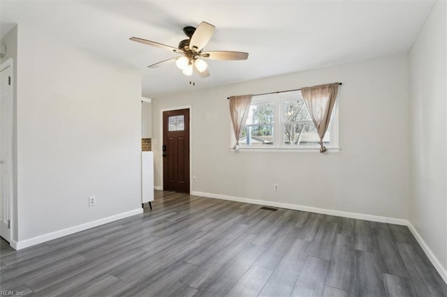 interior space with dark wood-type flooring and ceiling fan