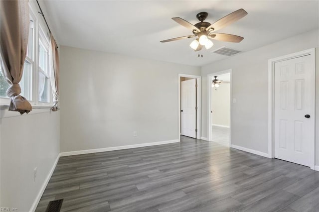 unfurnished bedroom featuring dark wood-type flooring and ceiling fan