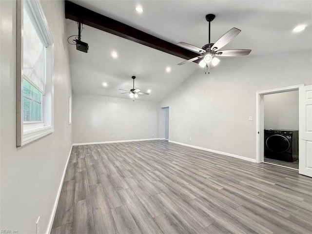 unfurnished living room with washer / clothes dryer, ceiling fan, light wood-type flooring, and lofted ceiling with beams