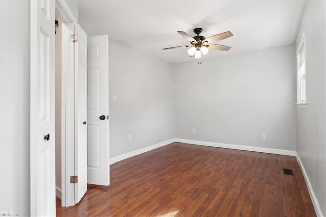 empty room with dark hardwood / wood-style flooring and ceiling fan