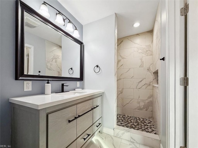 bathroom with vanity and a tile shower