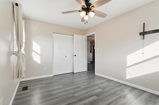 unfurnished bedroom with wood-type flooring, a closet, and ceiling fan