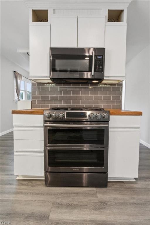 kitchen with stainless steel appliances, white cabinetry, and tasteful backsplash