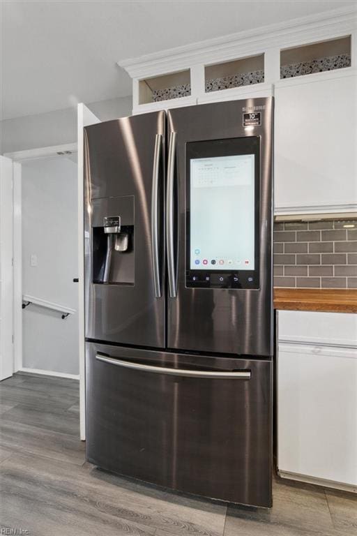 details featuring white cabinetry, wood counters, stainless steel fridge, and hardwood / wood-style floors