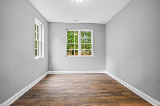 empty room with dark hardwood / wood-style flooring