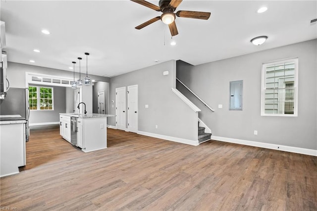 kitchen featuring sink, white cabinetry, a center island with sink, light hardwood / wood-style flooring, and pendant lighting