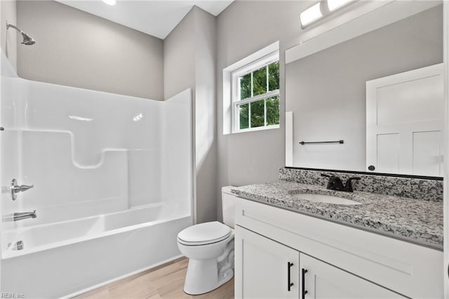 full bathroom with vanity, hardwood / wood-style floors, shower / washtub combination, and toilet