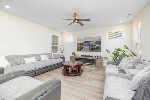 living room with ceiling fan and light hardwood / wood-style flooring