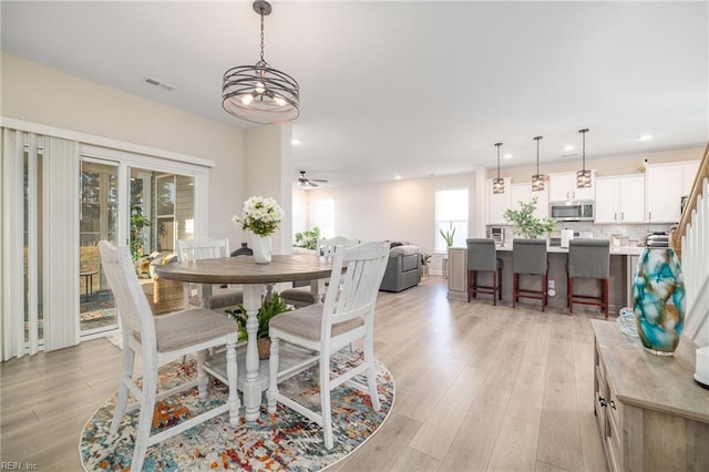 dining space with light hardwood / wood-style flooring and ceiling fan