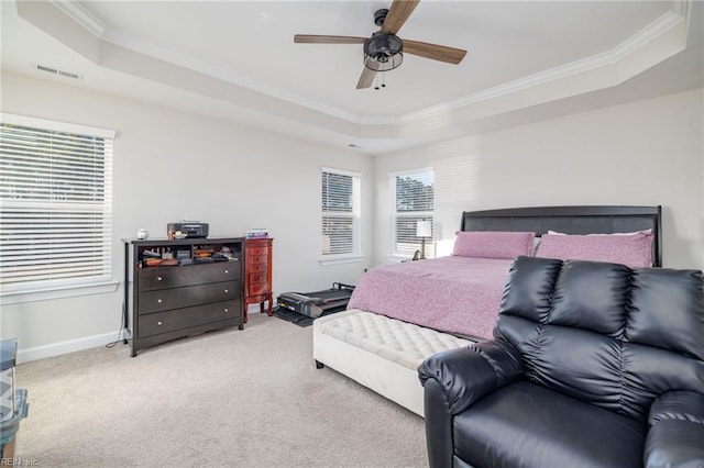 bedroom with ornamental molding, a raised ceiling, ceiling fan, and carpet