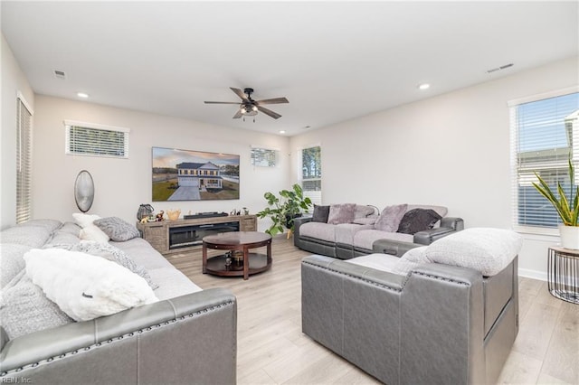 living room with light hardwood / wood-style floors and ceiling fan