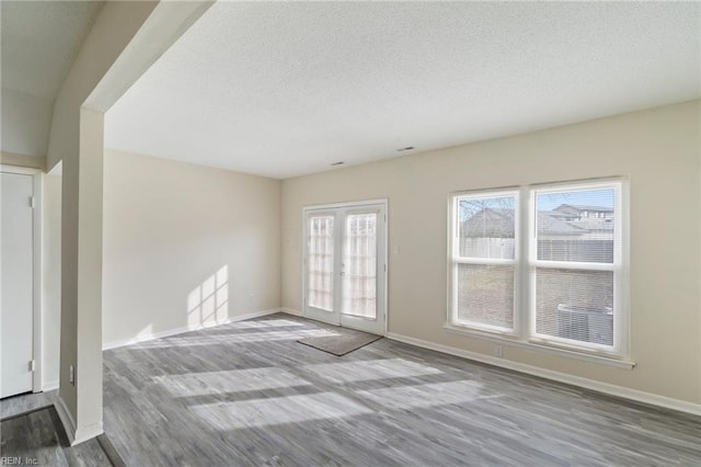 unfurnished room featuring a textured ceiling and light hardwood / wood-style floors