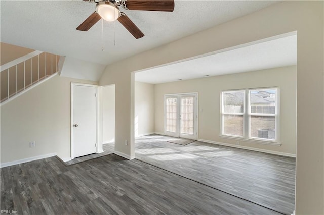 unfurnished living room featuring dark wood-type flooring, ceiling fan, french doors, and a textured ceiling