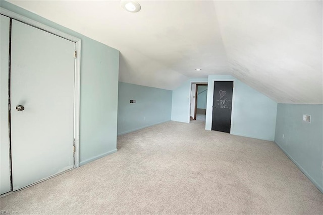 bonus room with light carpet and vaulted ceiling