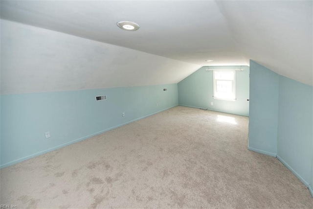 bonus room featuring vaulted ceiling and light colored carpet