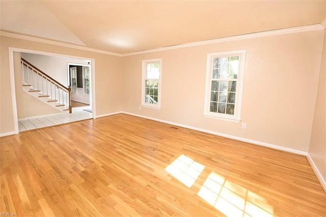 spare room featuring light hardwood / wood-style flooring, ornamental molding, and plenty of natural light