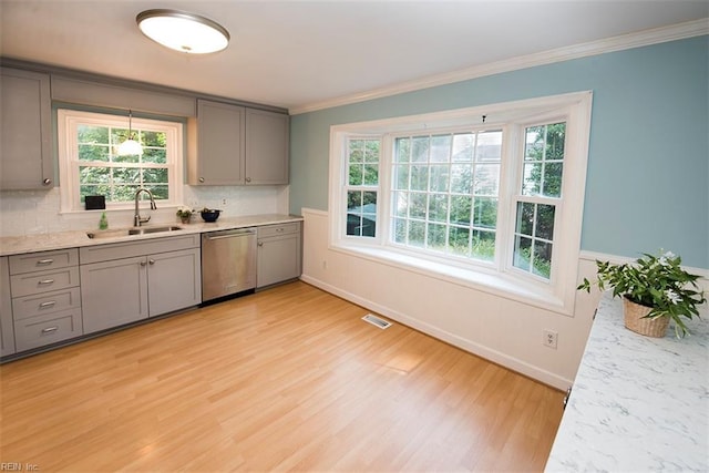 kitchen with sink, light hardwood / wood-style flooring, gray cabinetry, ornamental molding, and stainless steel dishwasher