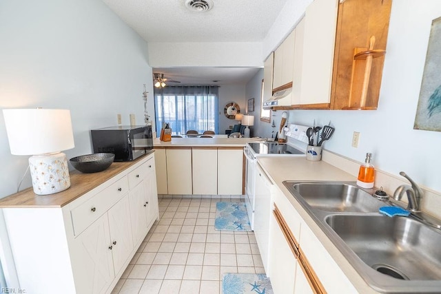 kitchen featuring white cabinetry, sink, light tile patterned floors, kitchen peninsula, and a textured ceiling