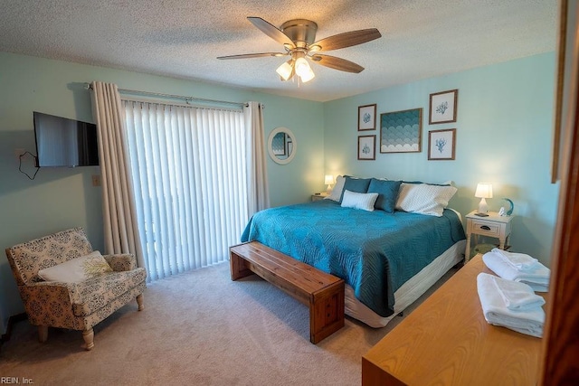 bedroom with ceiling fan, light colored carpet, and a textured ceiling