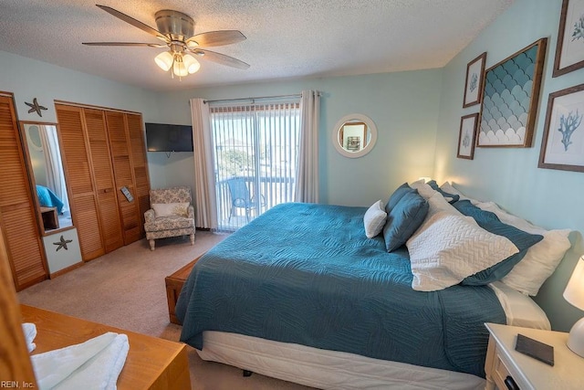 bedroom with ceiling fan, access to outside, light carpet, and a textured ceiling