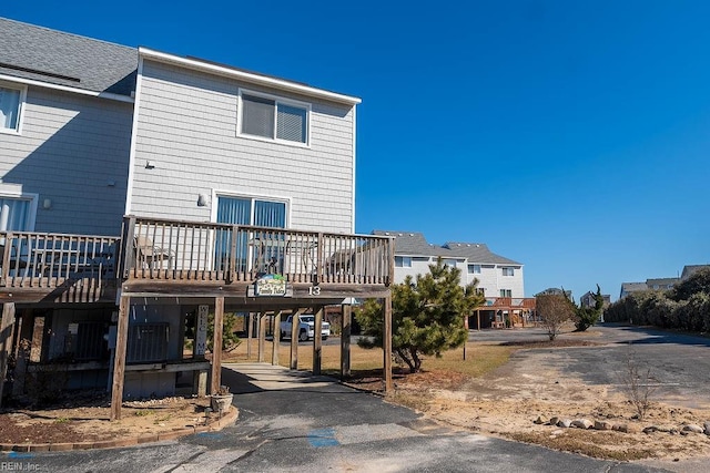 rear view of property with a carport and a deck