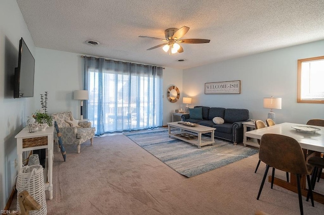 living room with ceiling fan, carpet, and a textured ceiling