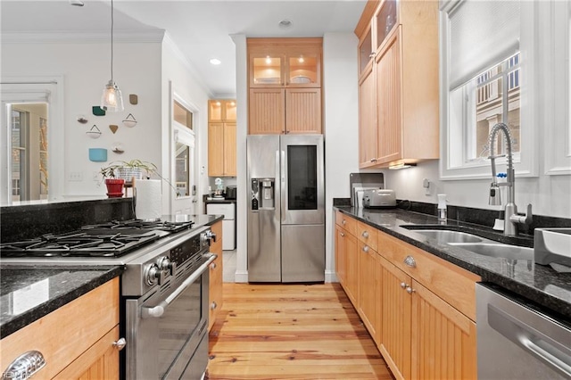 kitchen featuring sink, stainless steel appliances, and dark stone counters