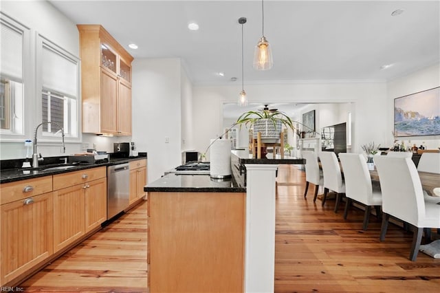 kitchen featuring sink, light hardwood / wood-style flooring, appliances with stainless steel finishes, a kitchen island, and pendant lighting