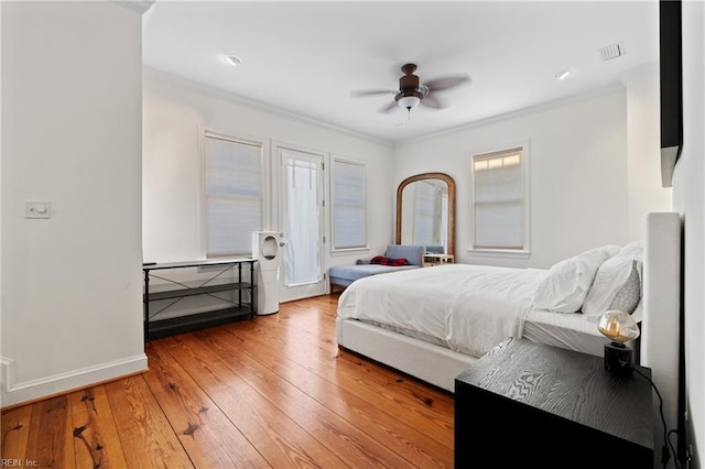 bedroom featuring multiple windows, wood-type flooring, ceiling fan, and crown molding