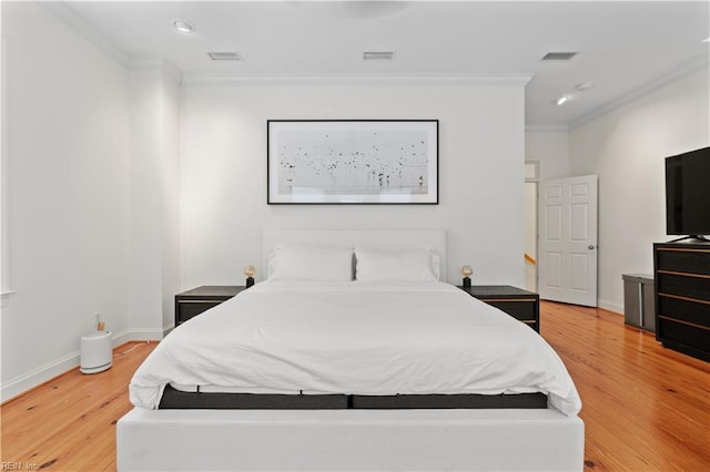 bedroom with ornamental molding and light hardwood / wood-style floors