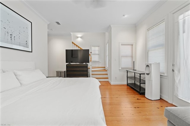 bedroom featuring crown molding and light hardwood / wood-style floors