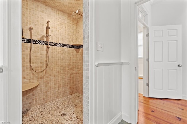 bathroom with hardwood / wood-style flooring and tiled shower