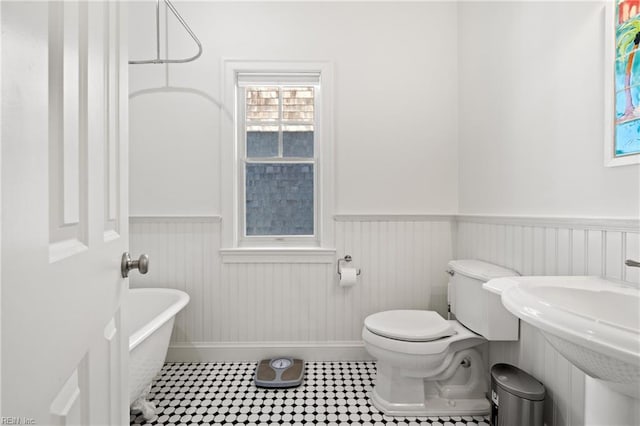 bathroom with a bath, sink, and toilet