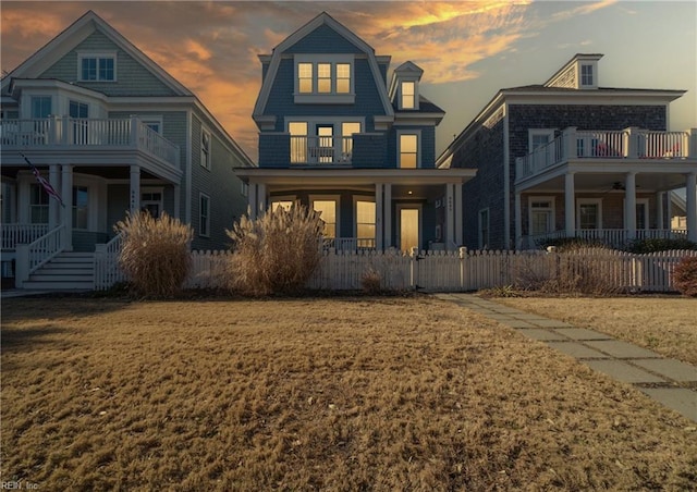 view of front of house featuring a yard and a balcony