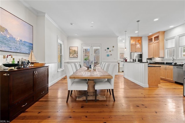 dining area featuring french doors, ornamental molding, sink, and light hardwood / wood-style flooring