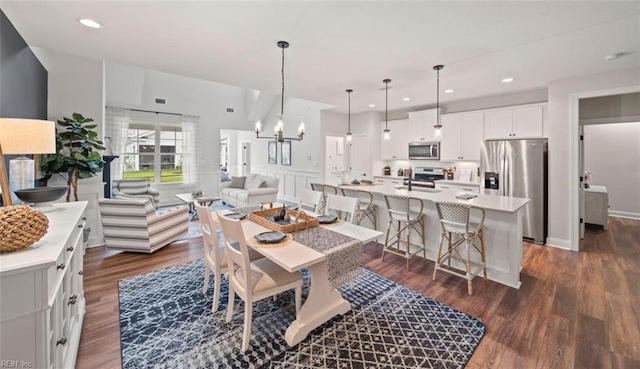 dining room featuring dark hardwood / wood-style floors, sink, and a notable chandelier