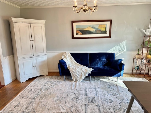 living area with an inviting chandelier, ornamental molding, and light wood-type flooring