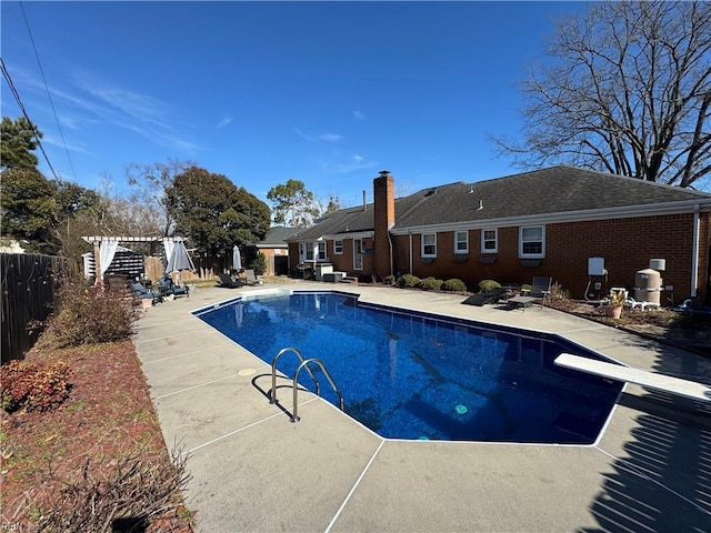 view of swimming pool with a pergola, a patio area, and a diving board