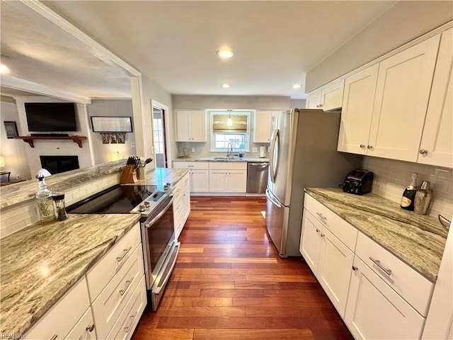 kitchen featuring white cabinetry, dark hardwood / wood-style flooring, light stone countertops, and appliances with stainless steel finishes