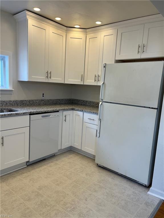 kitchen featuring white cabinetry, sink, and white appliances