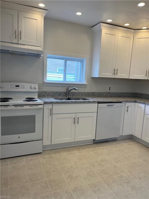 kitchen with white cabinetry, sink, white appliances, and dark stone counters