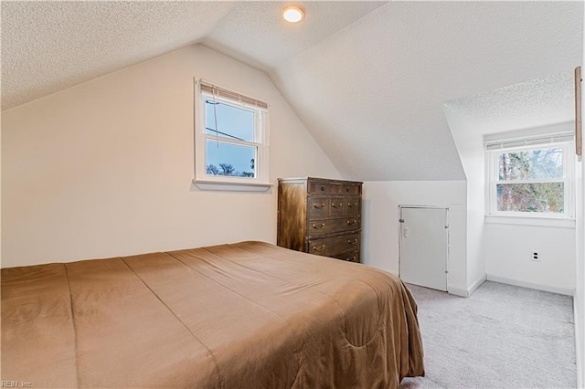 carpeted bedroom with vaulted ceiling and a textured ceiling