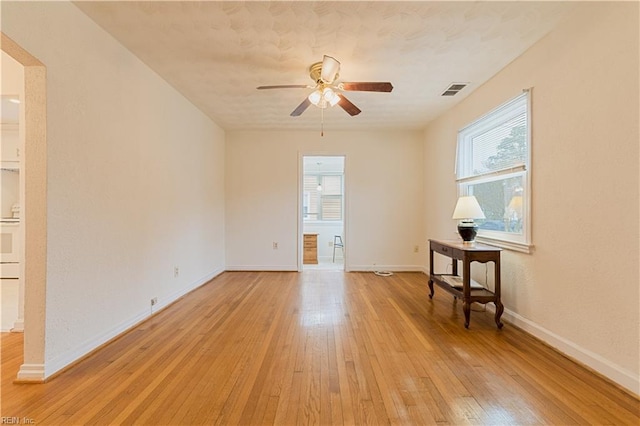 empty room with light hardwood / wood-style floors and ceiling fan