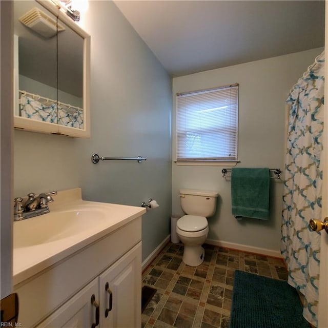 bathroom featuring vanity, lofted ceiling, and toilet