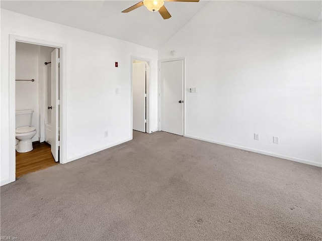 unfurnished bedroom with ceiling fan, ensuite bath, carpet flooring, and high vaulted ceiling