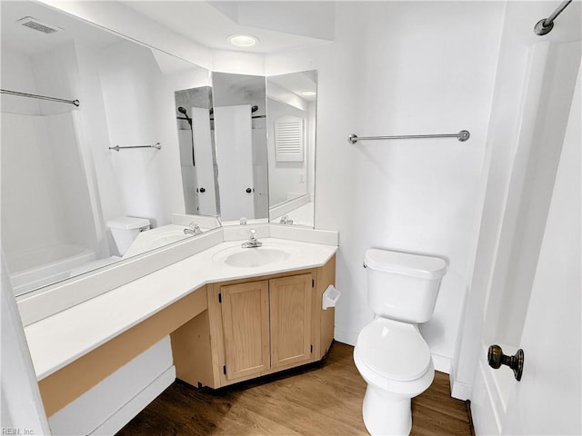 bathroom featuring wood-type flooring, vanity, and toilet