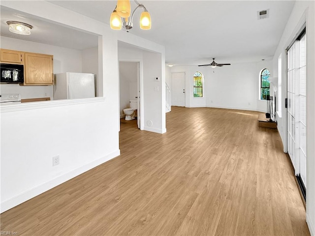 unfurnished living room with ceiling fan with notable chandelier and light wood-type flooring