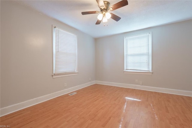 empty room with a textured ceiling, ceiling fan, and light wood-type flooring